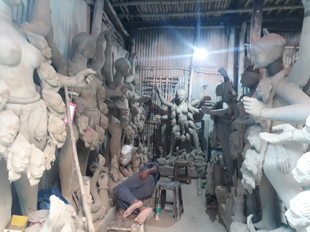 פסל עובד על אלילי חמר בשוק בקומארטולי, קולקטה