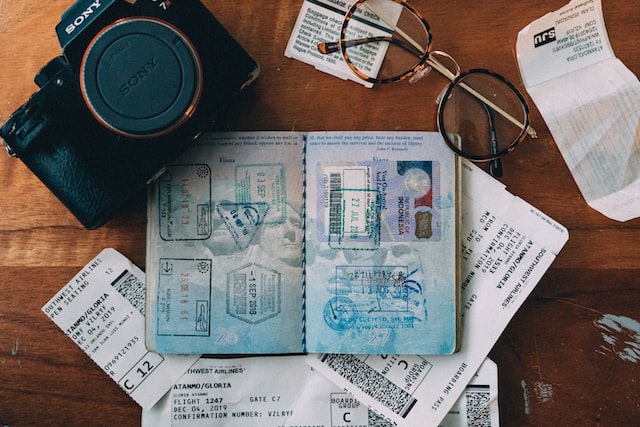 דרכון, מצלמה וכרטיסי טיסה מונחים על גבי שולחן